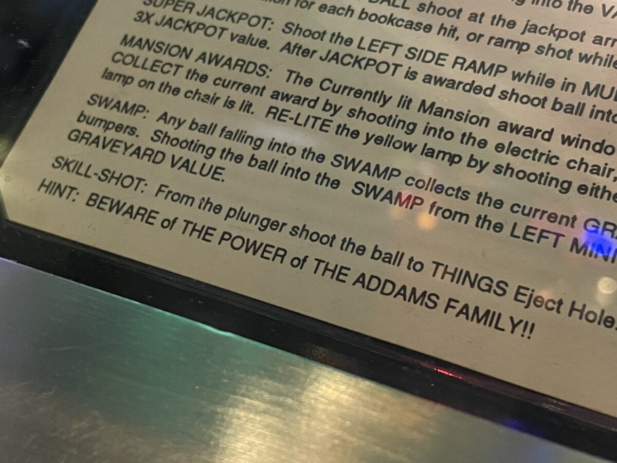 A picture of the instructions card on The Addams Family pinball machine. The final line reads "HINT: BEWARE of THE POWER of THE ADDAMS FAMILY!!"